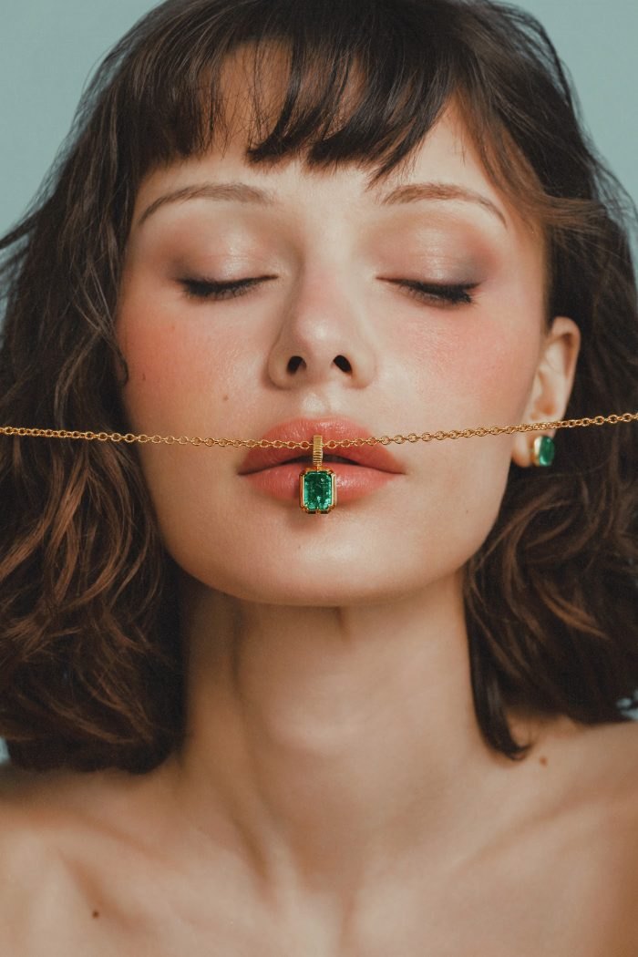 Model with eyes closed and the Kathryn pendant at her lips