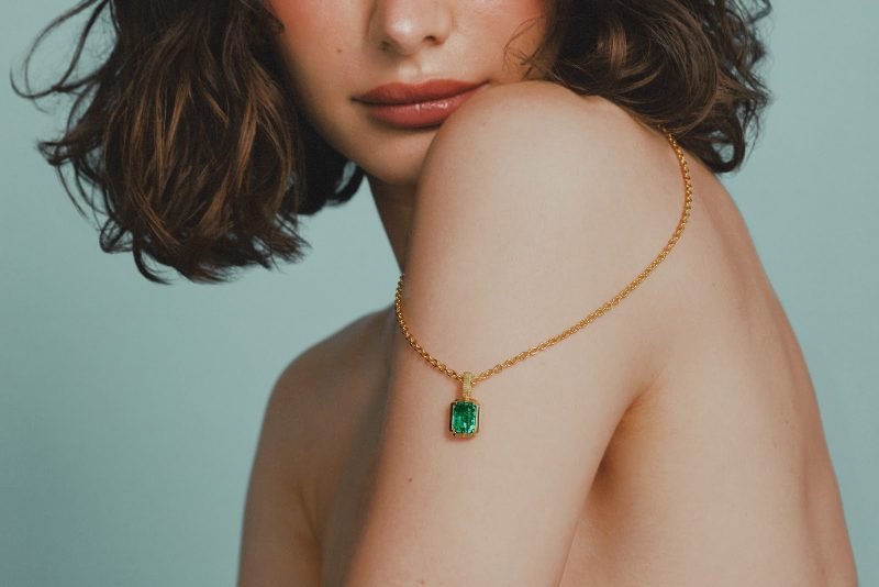 The Kathryn pendant on a fine gold chain draped over a bare shoulder