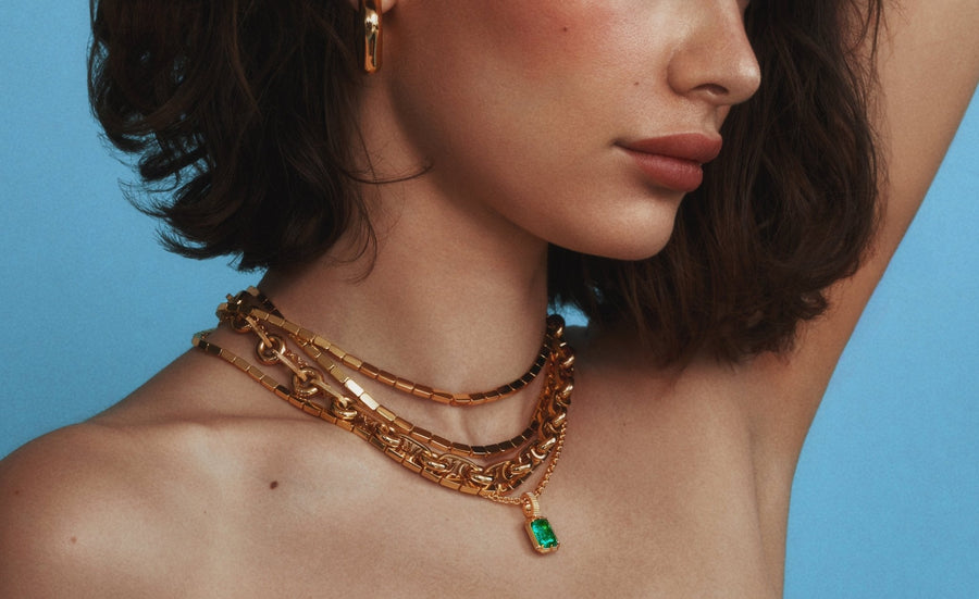 Stacked gold necklaces with the Kathryn emerald pendant